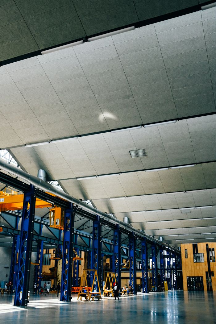 creative-03 Spacious indoor warehouse with steel beams and machinery, ideal for industrial applications.